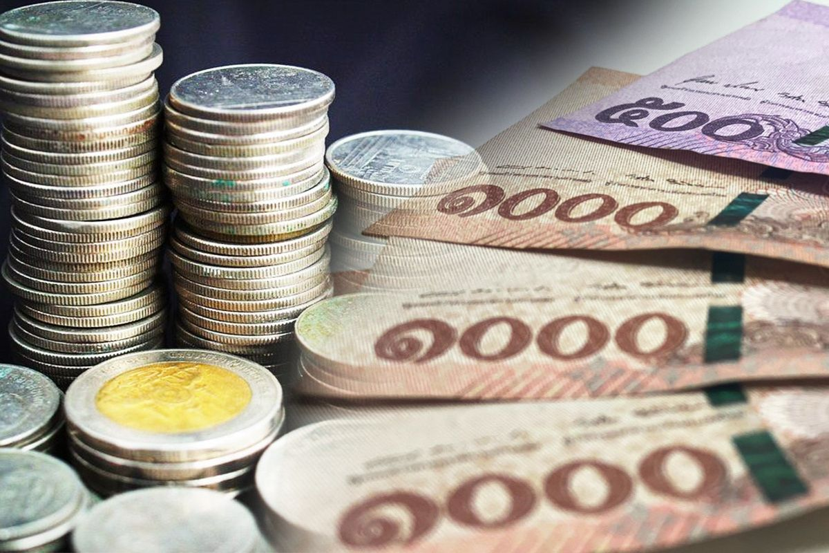 กองเหรียญและธนบัตรไทยประกอบเครื่องคำนวณเงินสมทบประกันสังคม